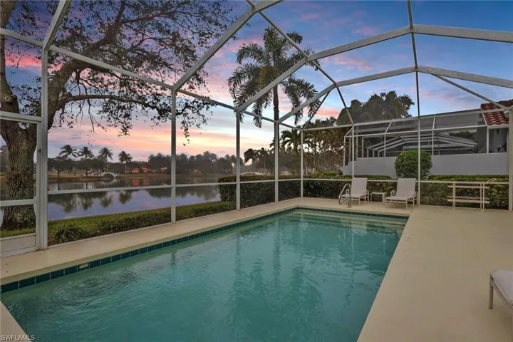 Swimming pool featuring a lanai, a sunroom, and a water view