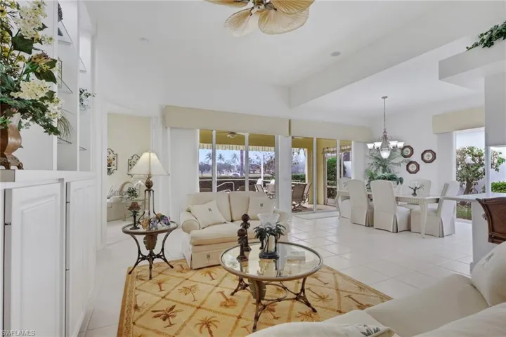 Living room with suspended lighting, a ceiling fan, and light tile patterned flooring