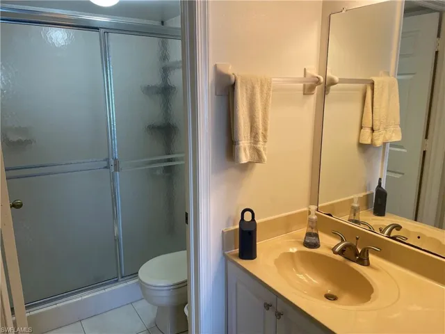Bathroom with vanity, a shower stall, and tile patterned floors