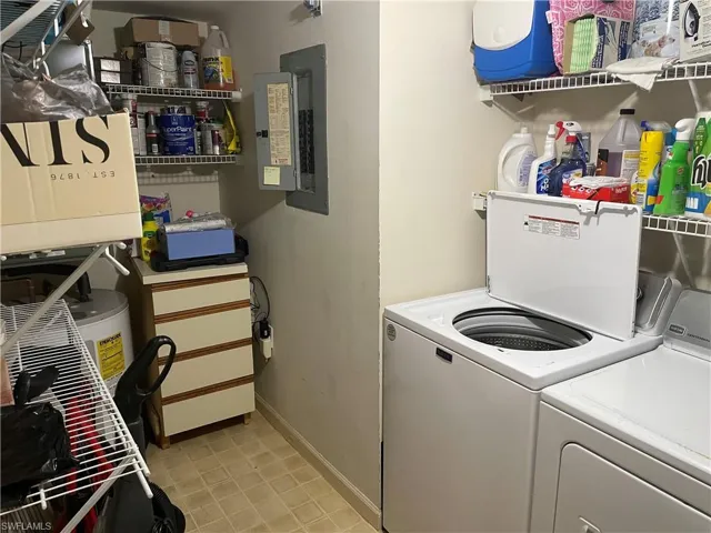 Laundry room with washing machine and clothes dryer and electric panel