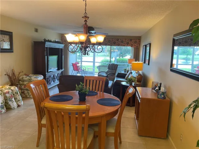 Dining room with light tile patterned floors and a chandelier