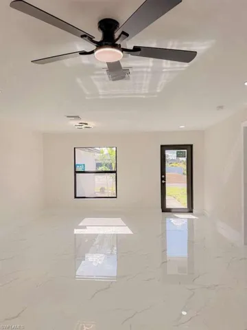 Spare room featuring light marble finish flooring and baseboards