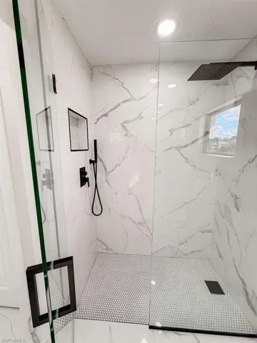 Bathroom featuring a marble finish shower, marble finish flooring, and recessed lighting
