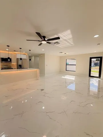 Unfurnished living room featuring recessed lighting, light marble finish flooring, and a ceiling fan