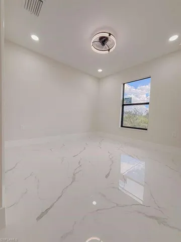 Spare room with marble tiled flooring and recessed lighting