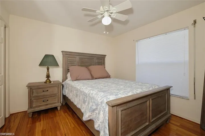 Bedroom with ceiling fan and dark wood-type flooring