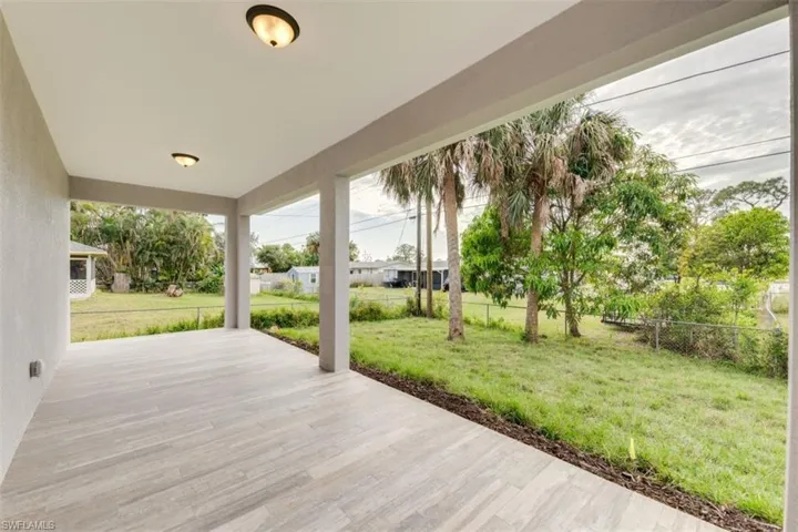 Wooden deck with a patio area and a lawn