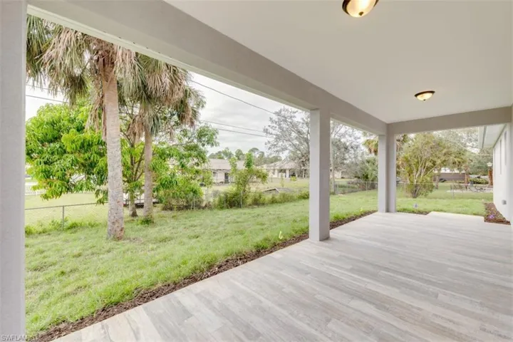 Wooden terrace featuring a patio area and a yard