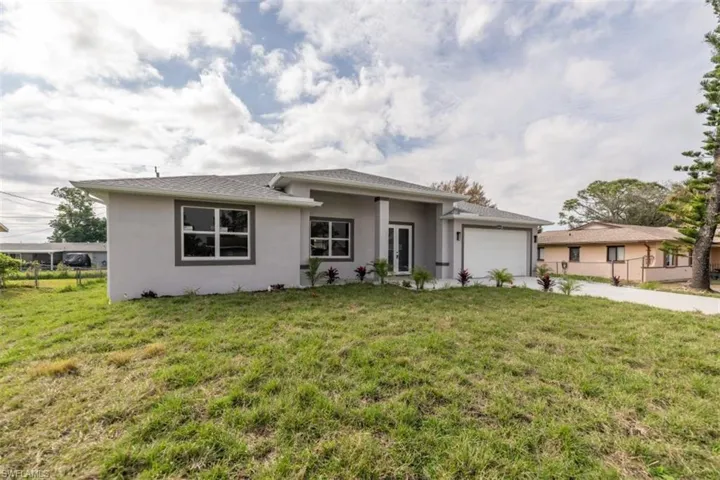 View of front facade with a garage and a front lawn