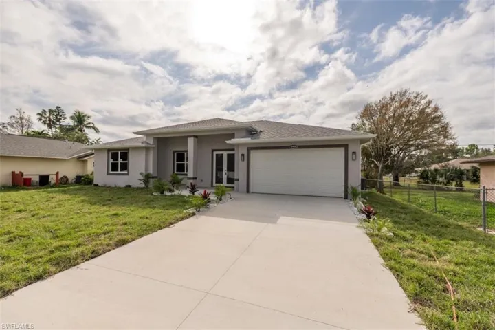 View of front facade featuring a front lawn and a garage