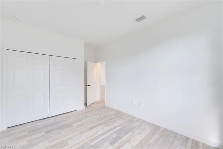 Unfurnished bedroom featuring light hardwood / wood-style flooring and a closet