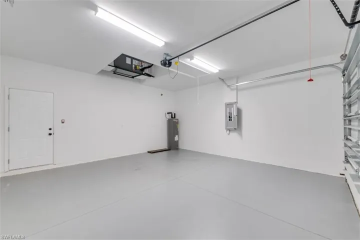 Garage featuring electric panel and water heater