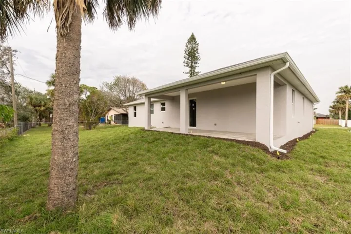 Rear view of house featuring a patio area and a yard