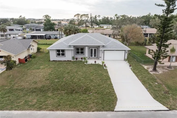 View of front of house with a garage and a front lawn