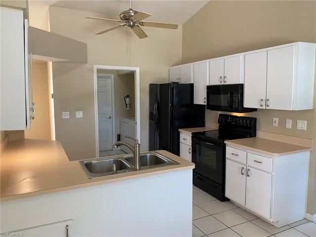 The kitchen boasts black Frigedaire appliances and stainless steel sink/faucet, under counter lighting, ceiling fan and tile flooring.