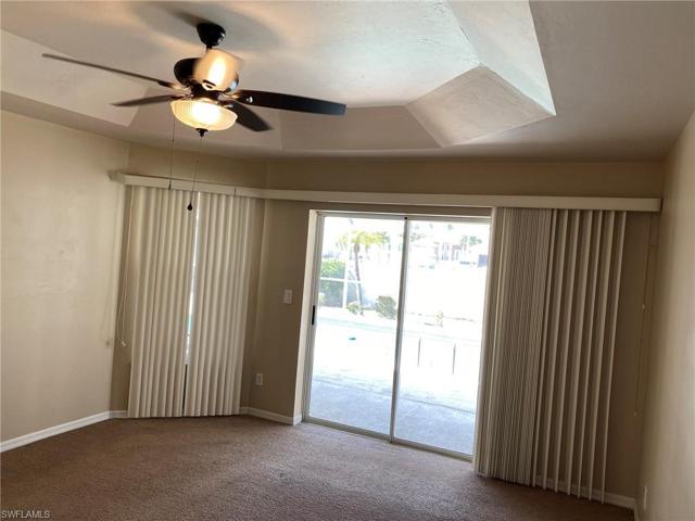 Vertical blinds cover the sliding glass door and large window allowing for the sunlight to spill into this large Master or give you privacy when you want it.