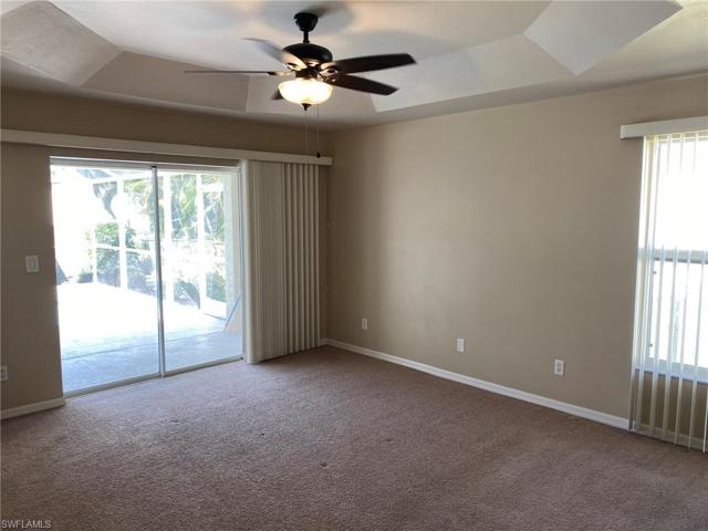 Carpeted Master bedroom opens to large Lanai with pocket Sliding glass doors and features a Tray ceiling and lighted ceiling fan.