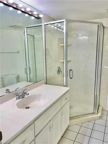 Bathroom featuring tile floors, toilet, walk in shower, and oversized vanity