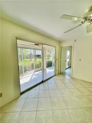 Tiled spare room featuring a wealth of natural light and ceiling fan