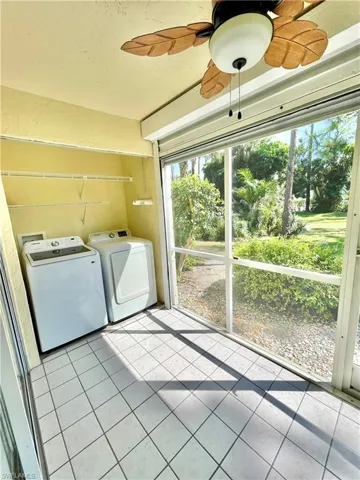 Clothes washing area featuring separate washer and dryer, ceiling fan, and light tile floors