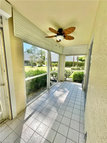 Unfurnished sunroom featuring ceiling fan