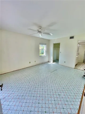 Tiled spare room featuring ceiling fan