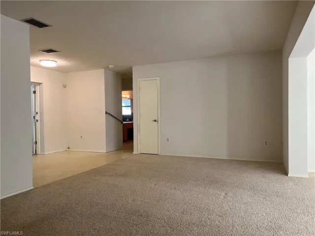 Empty room with light colored carpet