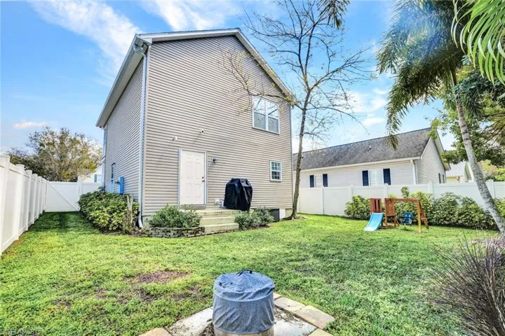 Rear view of property featuring a fenced backyard and a playground