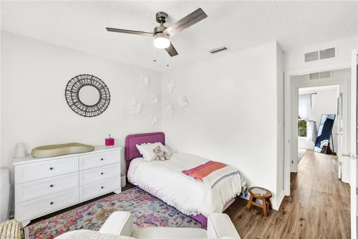 Bedroom with wood finished floors, a textured ceiling, and ceiling fan