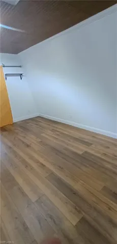 Unfurnished room featuring dark wood finished floors and baseboards
