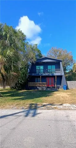 View of front of house featuring a balcony and a front yard