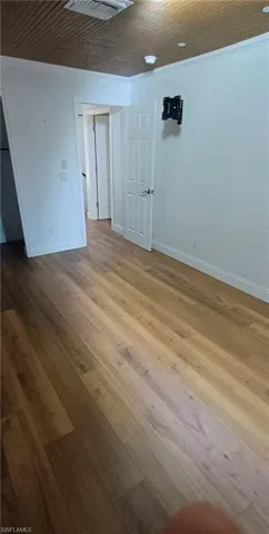 Unfurnished room featuring hardwood / wood-style flooring and wooden ceiling