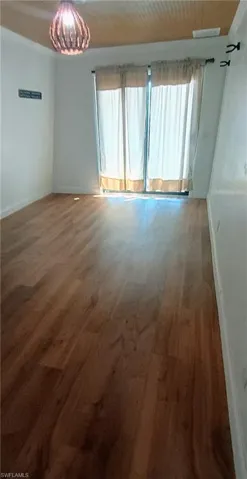 Unfurnished room featuring baseboards and wood finished floors