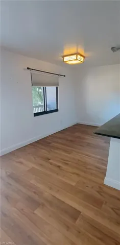 Empty room featuring baseboards and light wood-style flooring