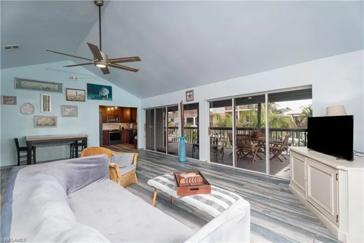 Living room featuring high vaulted ceiling, light hardwood / wood-style floors, and ceiling fan