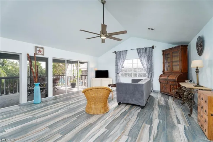Living room featuring high vaulted ceiling, ceiling fan, and hardwood / wood-style floors