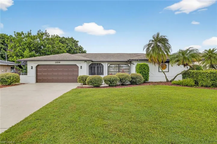 Single story home featuring stucco siding, a garage, a front yard, and concrete driveway