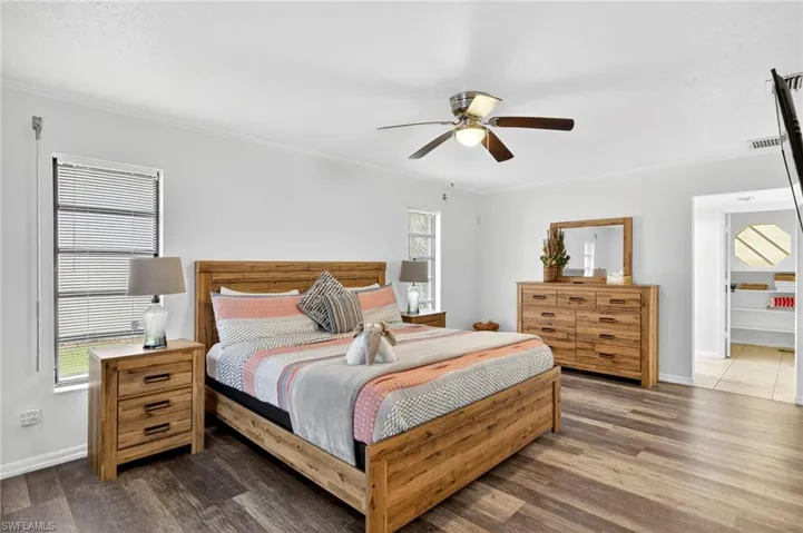 Bedroom featuring crown molding, wood finished floors, and ceiling fan