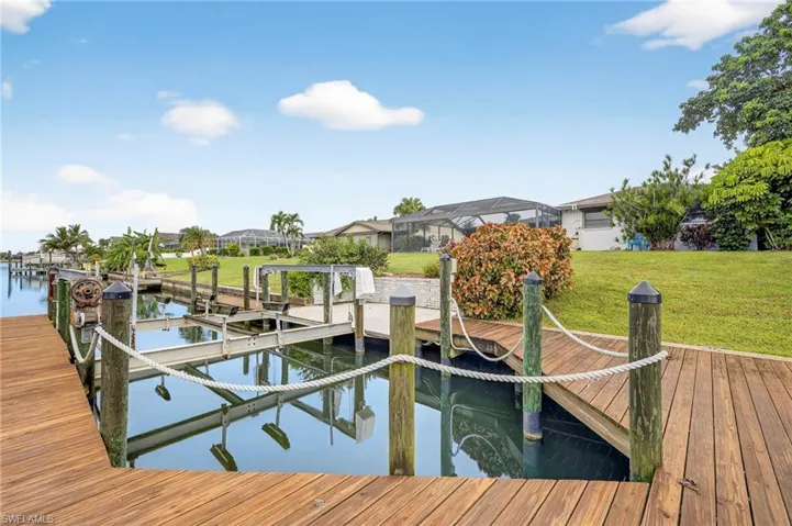 Dock area with a lawn, a water view, and a residential view