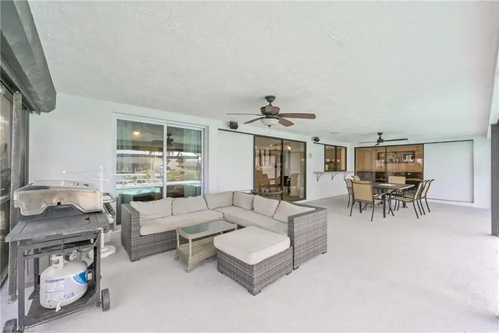 Living area featuring ceiling fan and a textured ceiling