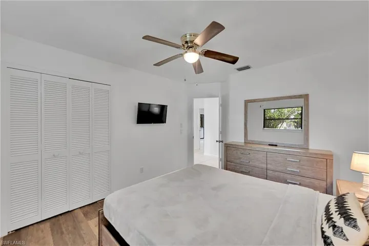Bedroom featuring light wood-style floors, a closet, and ceiling fan