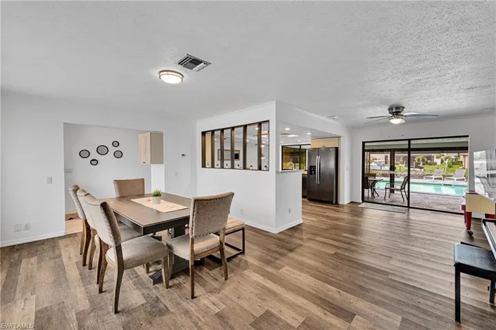 Dining area with a ceiling fan, light wood finished floors, and a textured ceiling