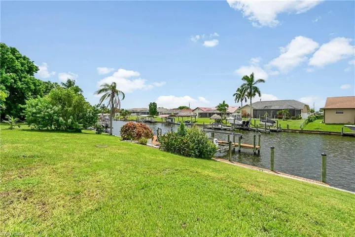Dock area with a lawn, a residential view, and a water view