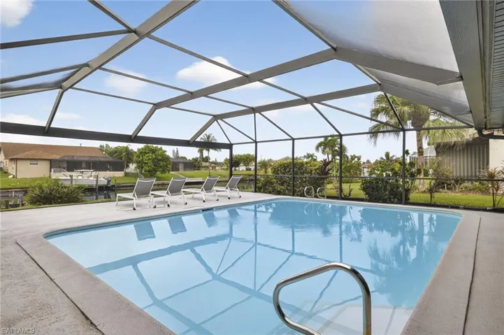 Swimming pool featuring a lanai, a sunroom, and a patio area