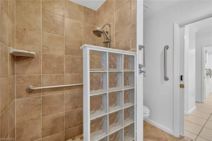 Bathroom featuring walk in shower and tile patterned flooring