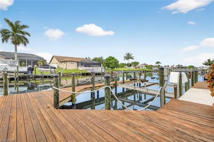 Dock area featuring boat lift, a water view, and a residential view