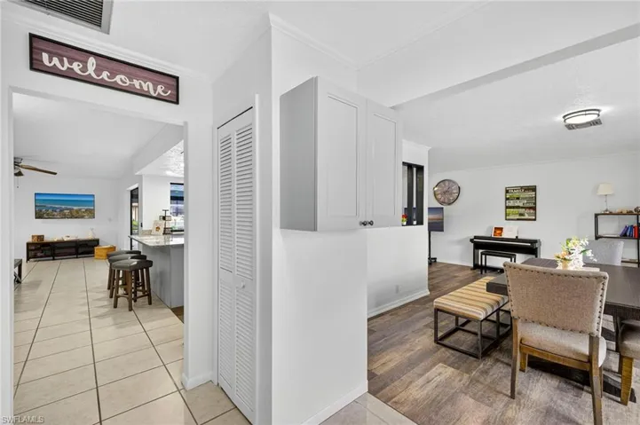 Dining space featuring light tile patterned floors, a ceiling fan, and ornamental molding