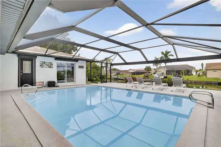 Swimming pool featuring a lanai, a patio, and a sunroom