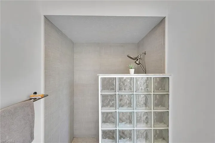 Full bath featuring a walk in shower and a textured ceiling