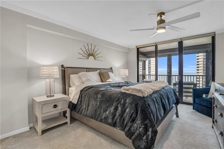 Bedroom with access to outside, ornamental molding, ceiling fan, and light colored carpet